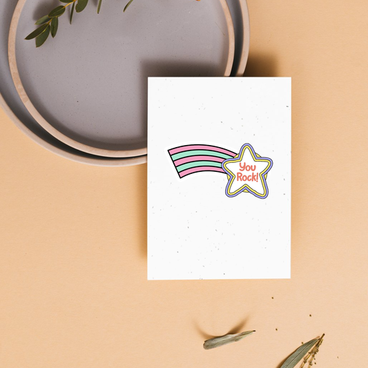 Greeting card with rainbow and star design on a beige surface