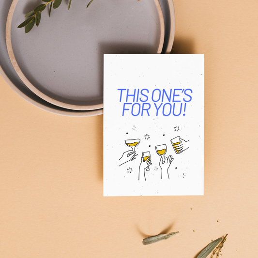 Greeting card with 'This one's for you!' text and illustrations of cheers on a beige background