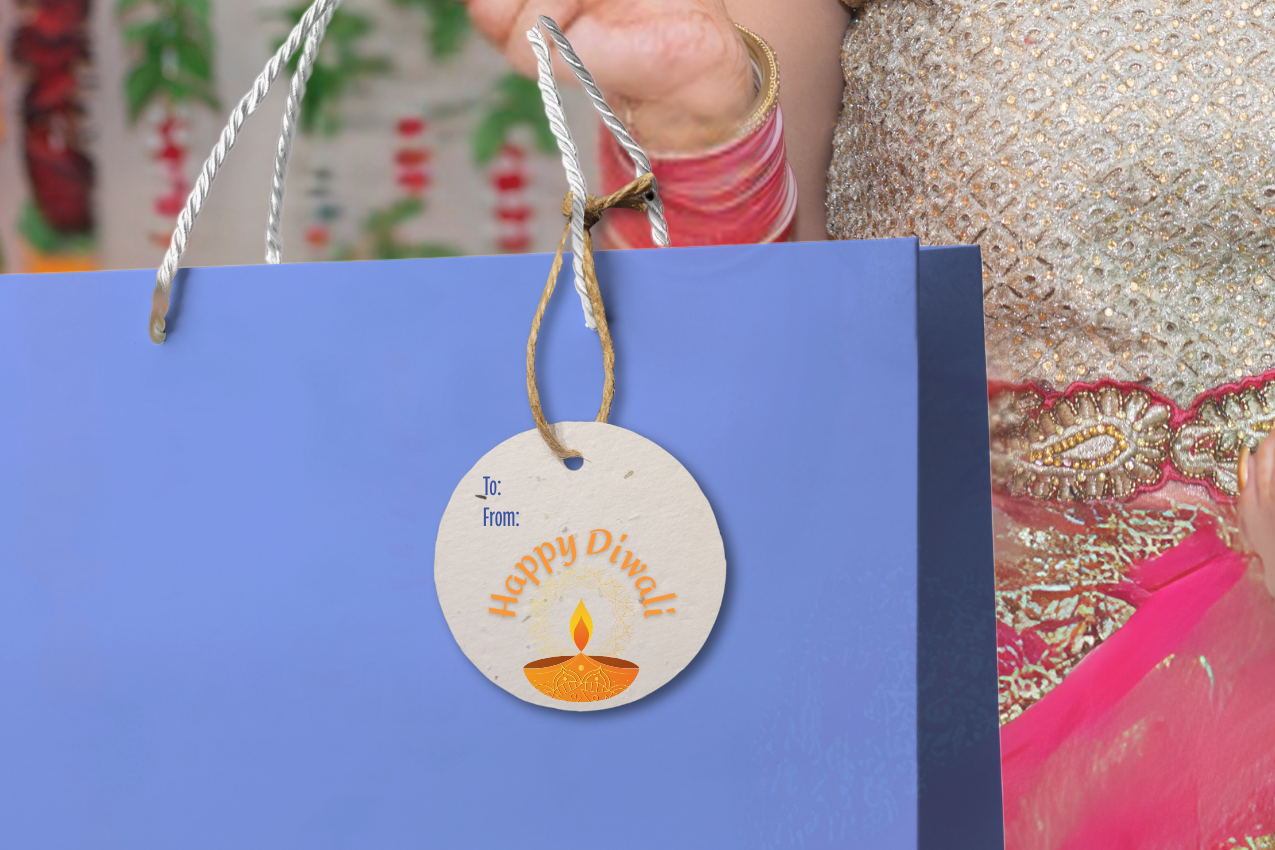Person holding a blue bag with a decorative Diwali gift tag. decorative background