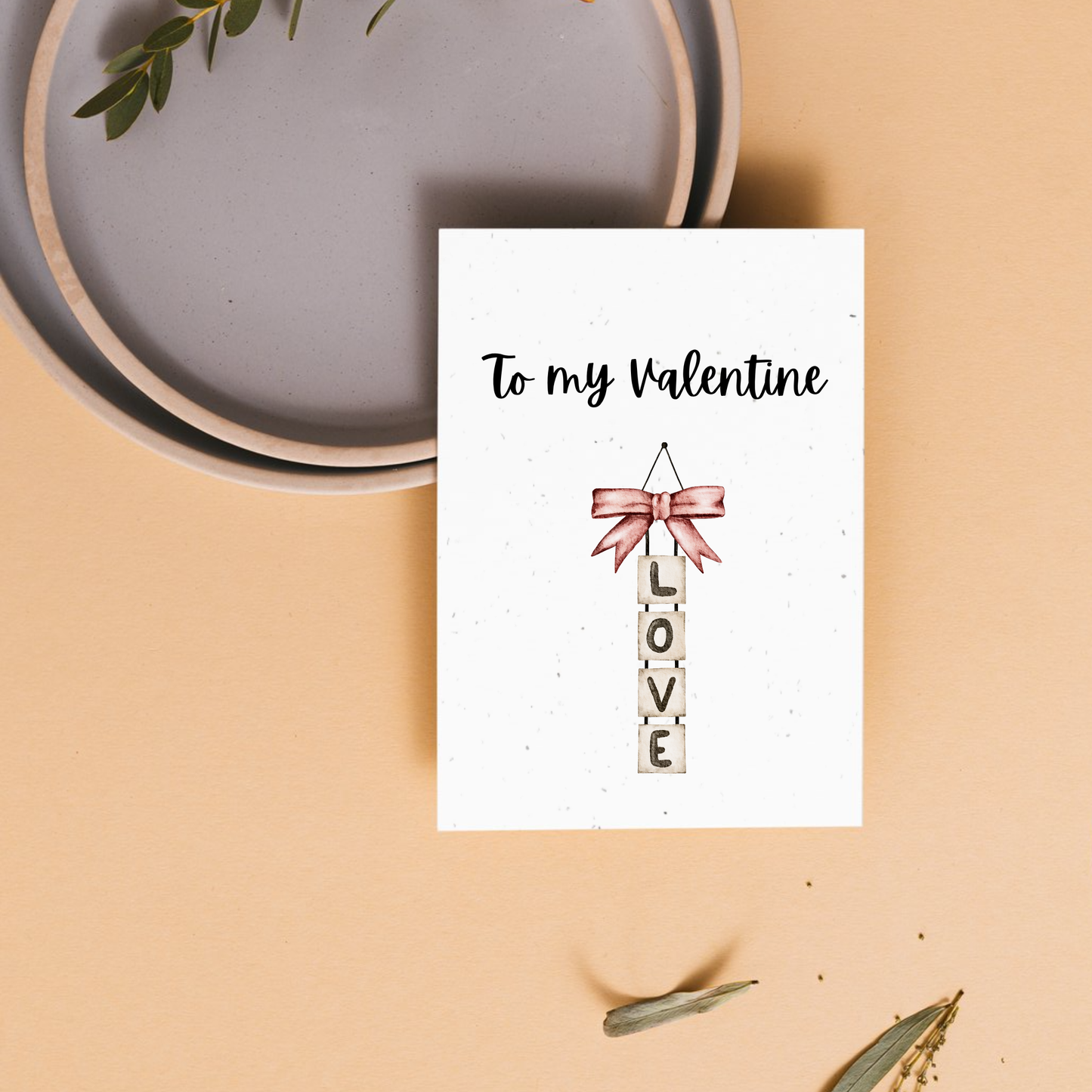 Valentine's Day card with 'To my Valentine' text and a pink bow with hanging tiles that spell out 'L O V E'