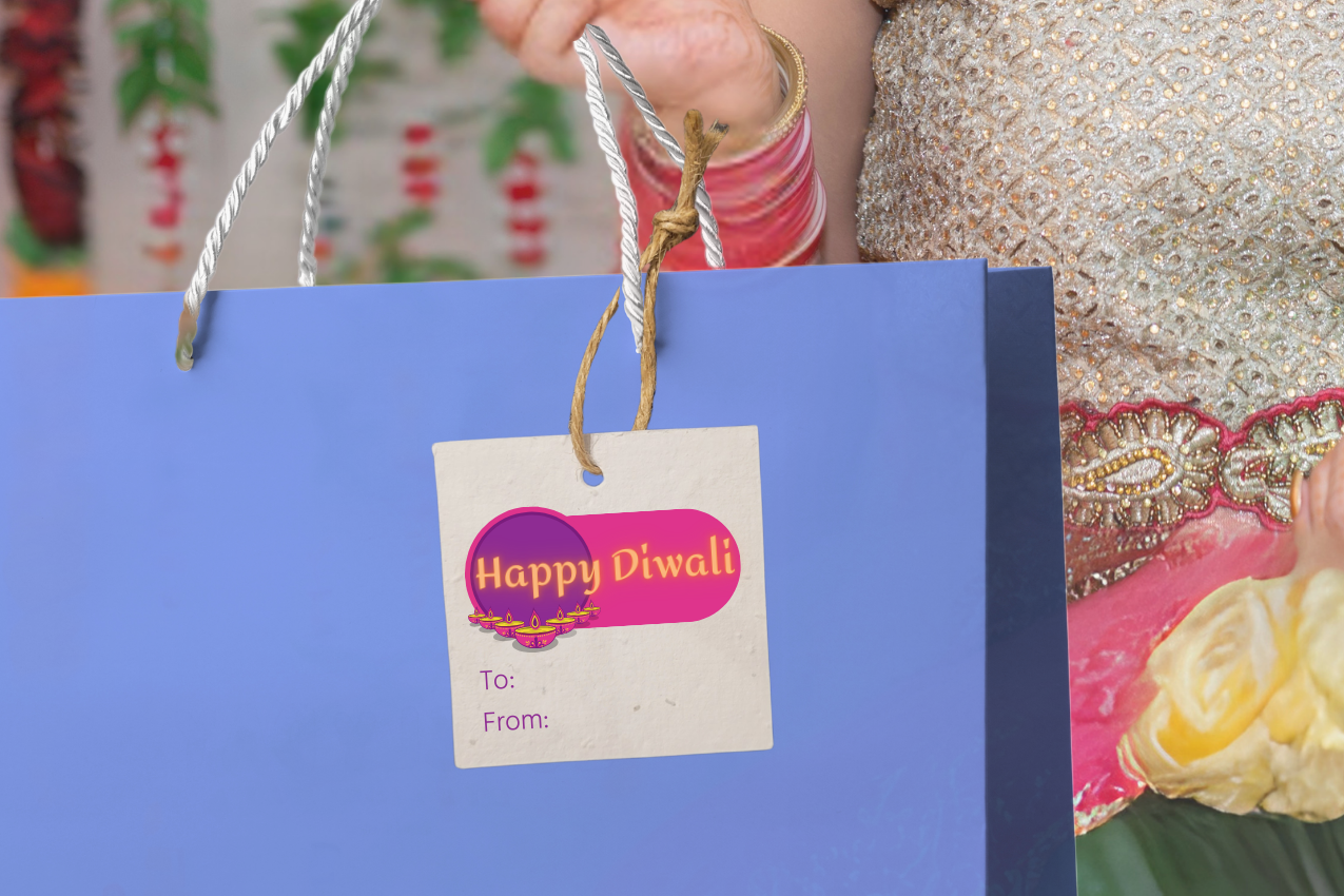 Woman holding a blue gift bag with a 'Happy Diwali' tag against a colorful background