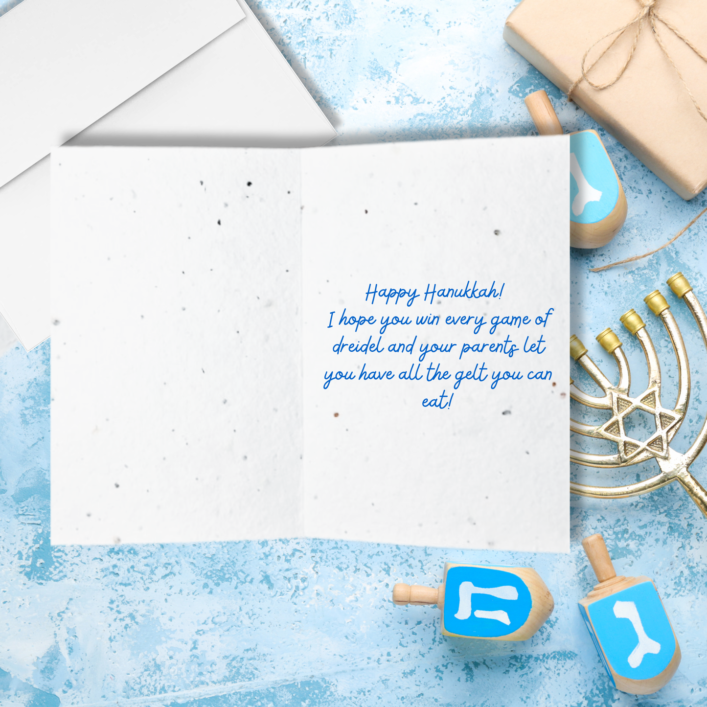 Hanukkah card with blue text 'happy Hanukkah I hope you win every game of dreidel and your parents let you have all the gelt you can eat!'