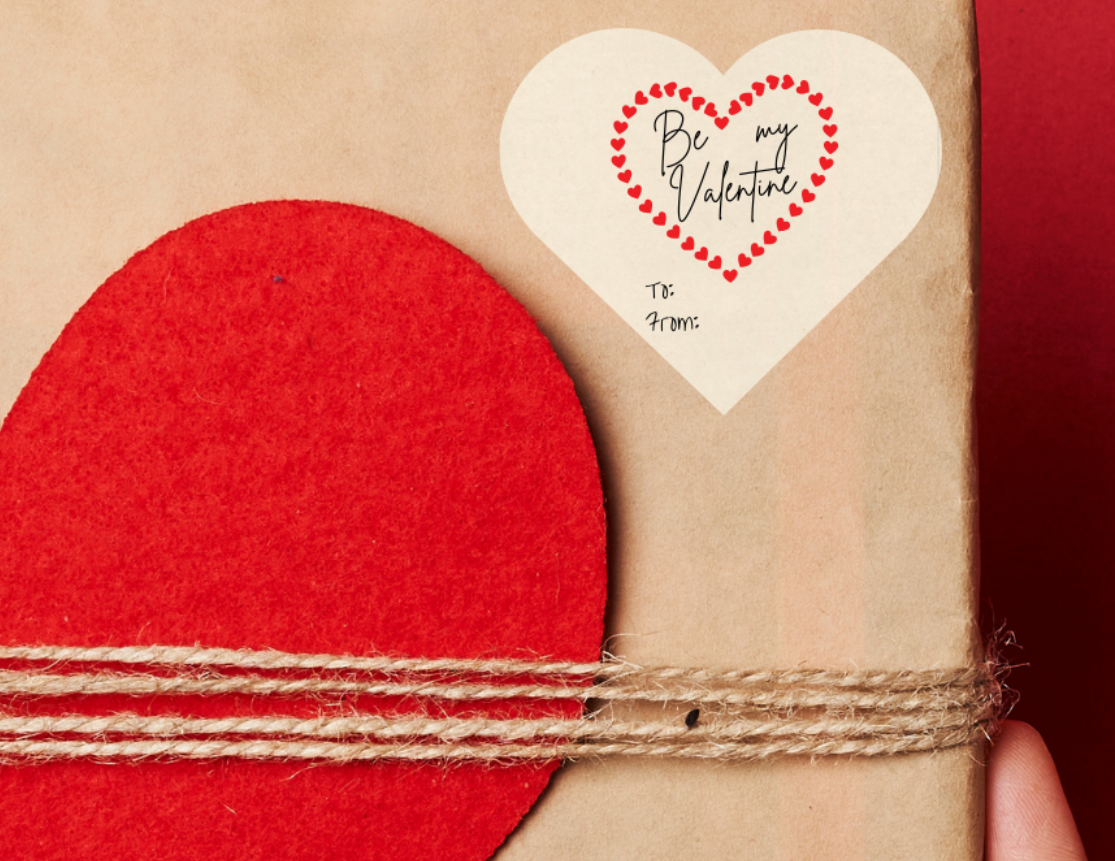 Heart shaped Gift sticker label for Valentine's day, with a  'Be my Valentine' text inside a heart, placed on a Gift box with red heart design held against a red background