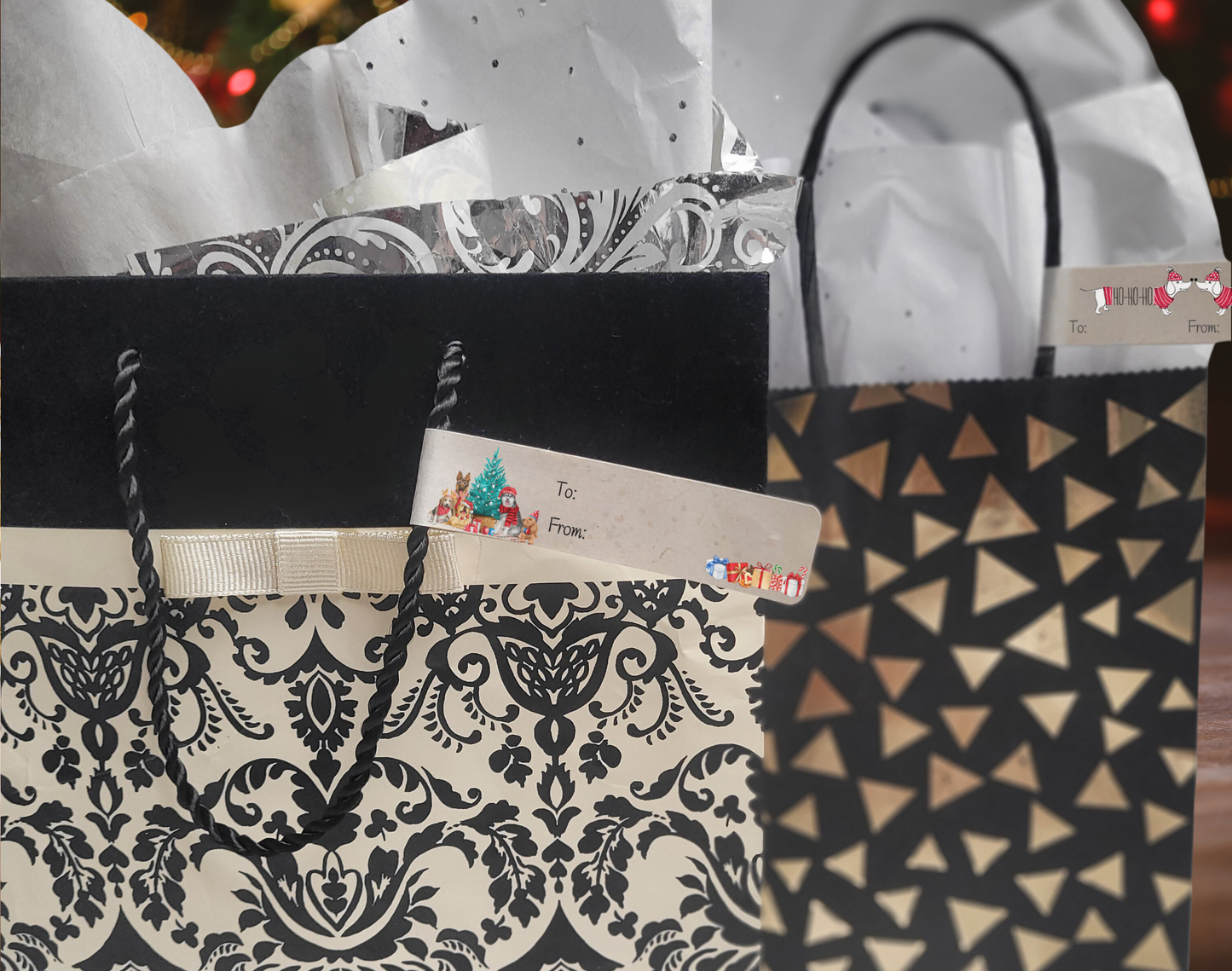 2 gift bags. One has a label with several dogs dressed in holiday gear around a Christmas Tre. The other bag has a label on it with 2 white daschund dogs one has "HO-HO-HO" written on it's body