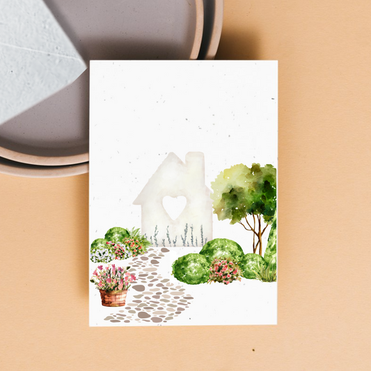 Front of card with garden and home with a heart shaped window. 