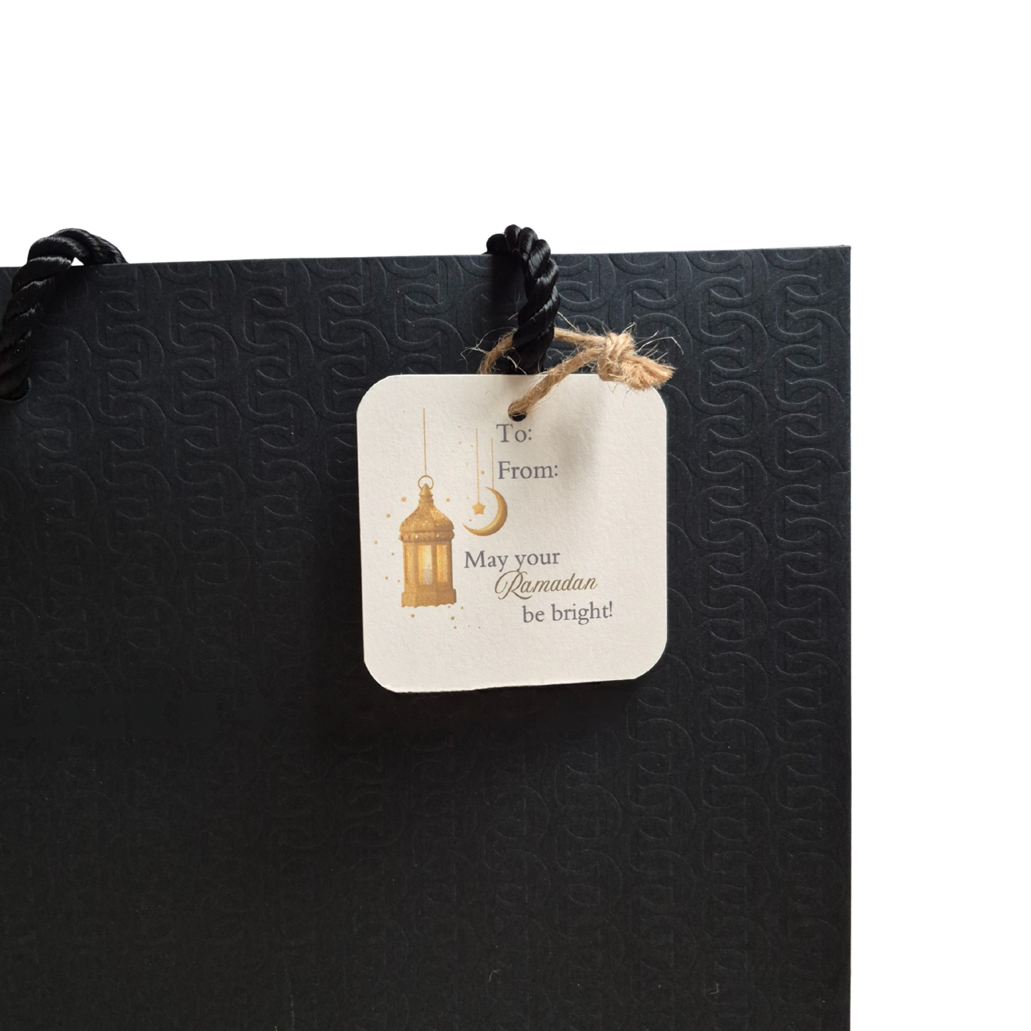 Black gift bag with a decorative gift tag featuring 'May your Ramadan be bright' text