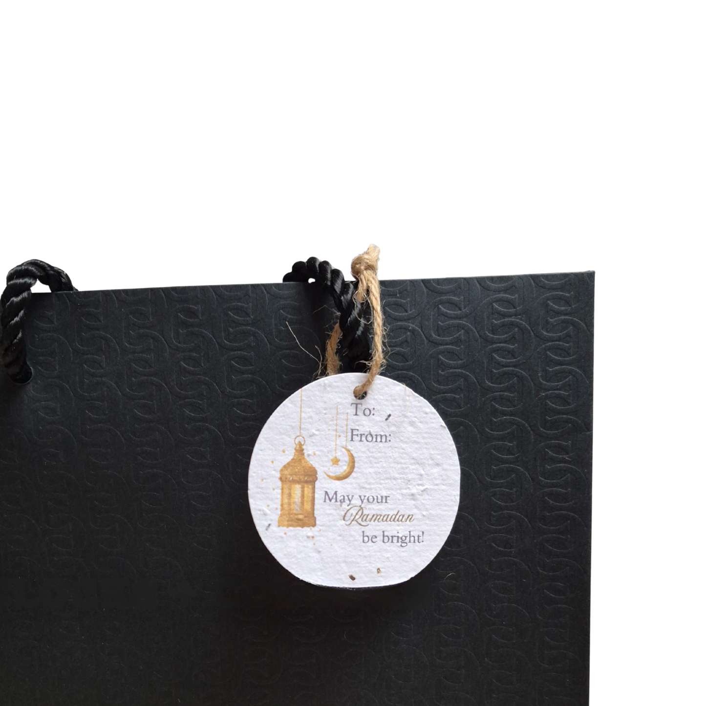 Black gift bag with a decorative seed paper gift tag featuring 'May your Ramadan be bright' text