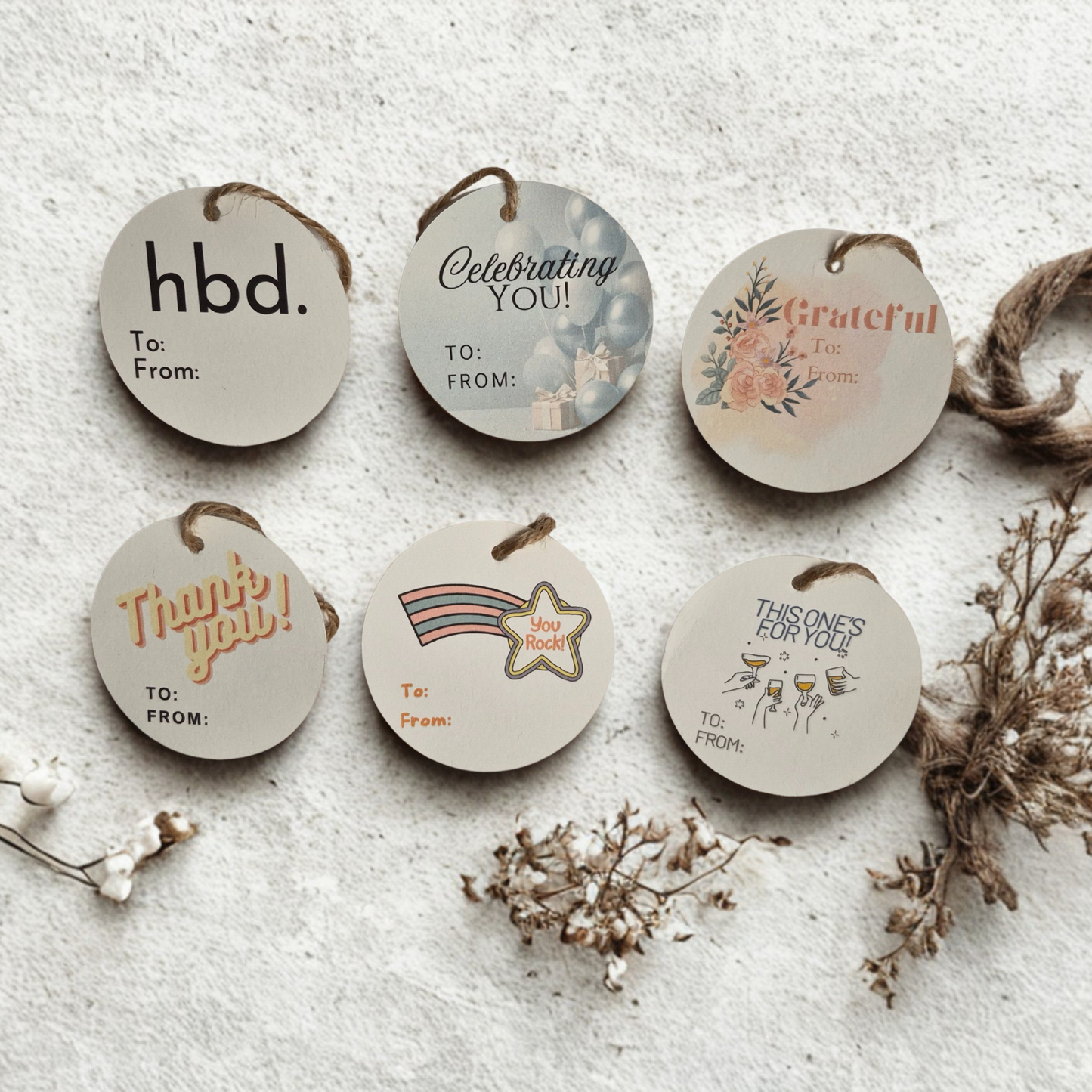 Set of six circle recycled gift tags with various messages on a textured surface.