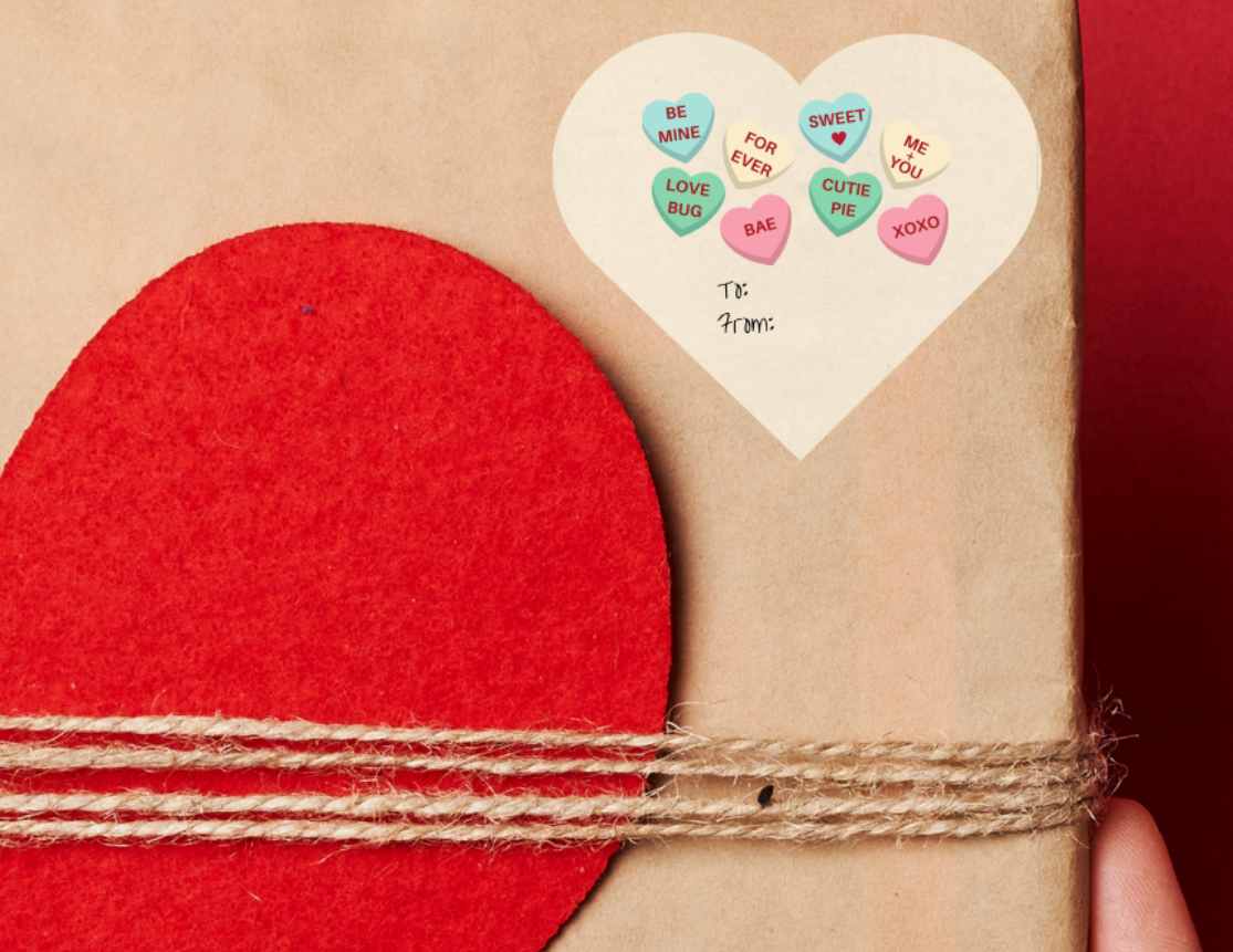 Heart shaped Gift sticker label for Valentine's day, with sweet heart candies placed on a Gift box with red heart design held against a red background