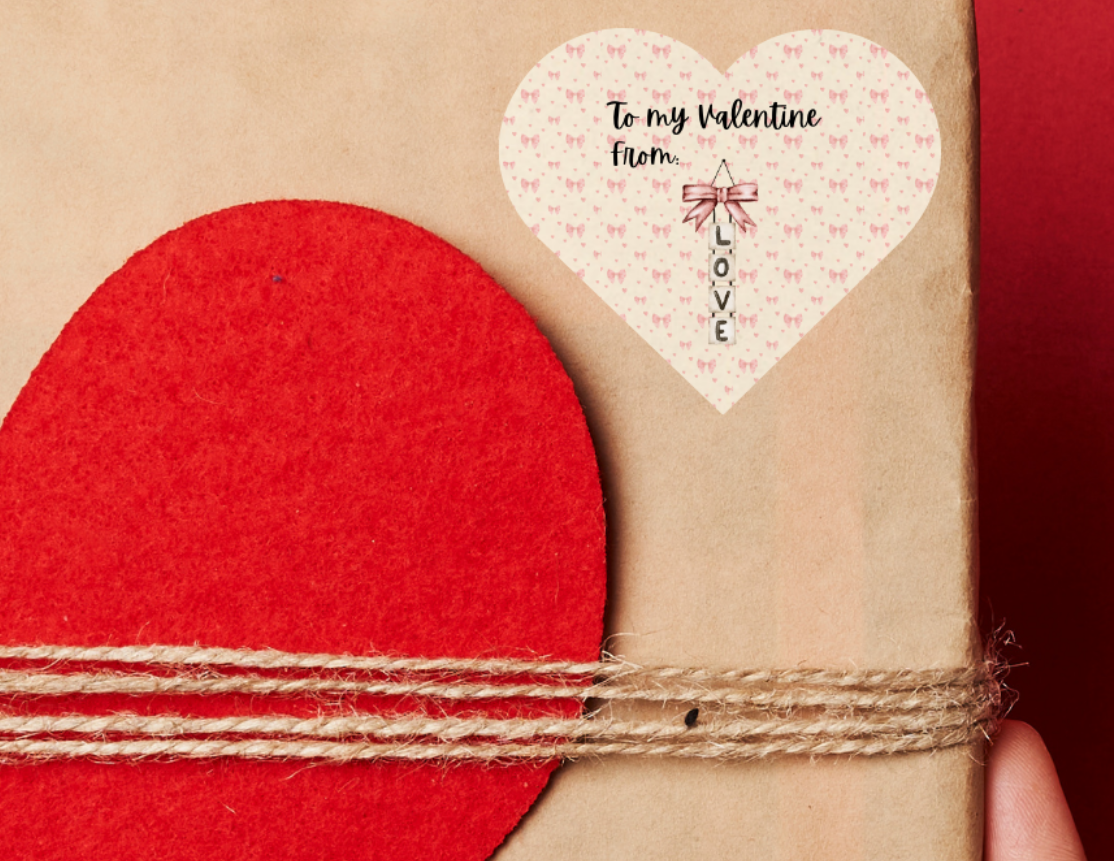 Heart shaped Gift sticker label for Valentine's day, with pink bows in the background and 'To my Valentine' text. and 'LOVE' hanging vertically. The heart shaped sticker label is placed on a Gift box with red heart design held against a red background
