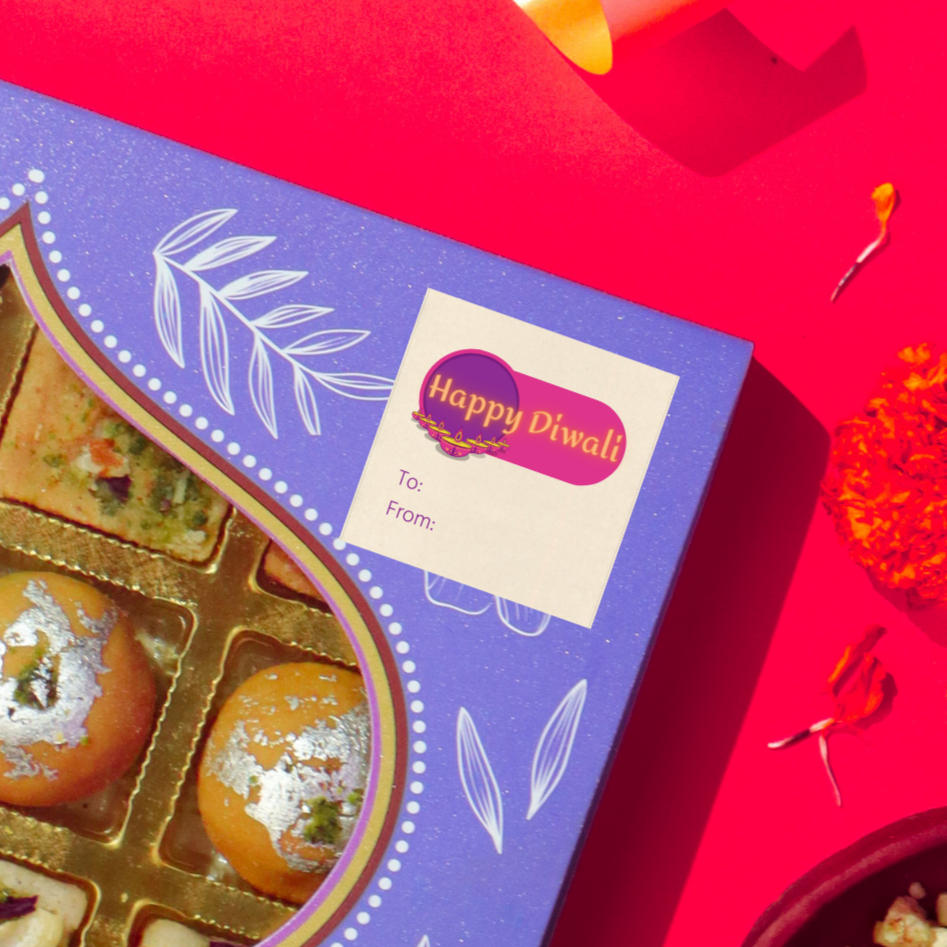 Diwali gift sticker, square, made from compostable sugarcane, with 'Happy Diwali' text and diyas in a v-formation illustration. The sticker label is placed on a gift box of Diwali sweets on a red background