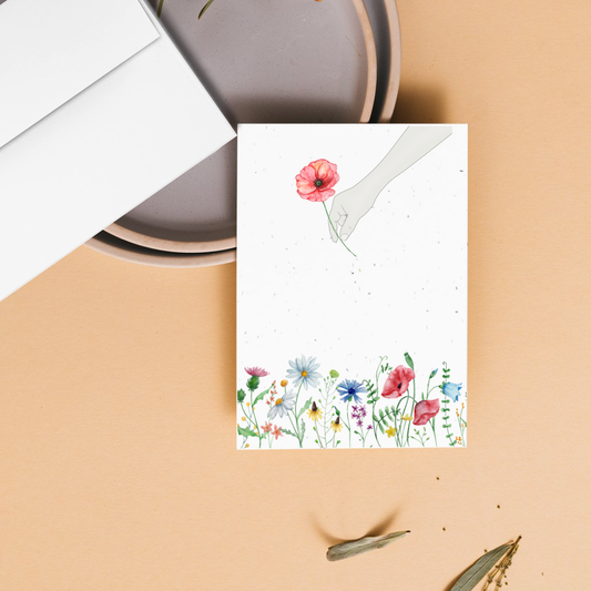 Mother's day Card with floral garden and one special flower being picked on a beige surface 
