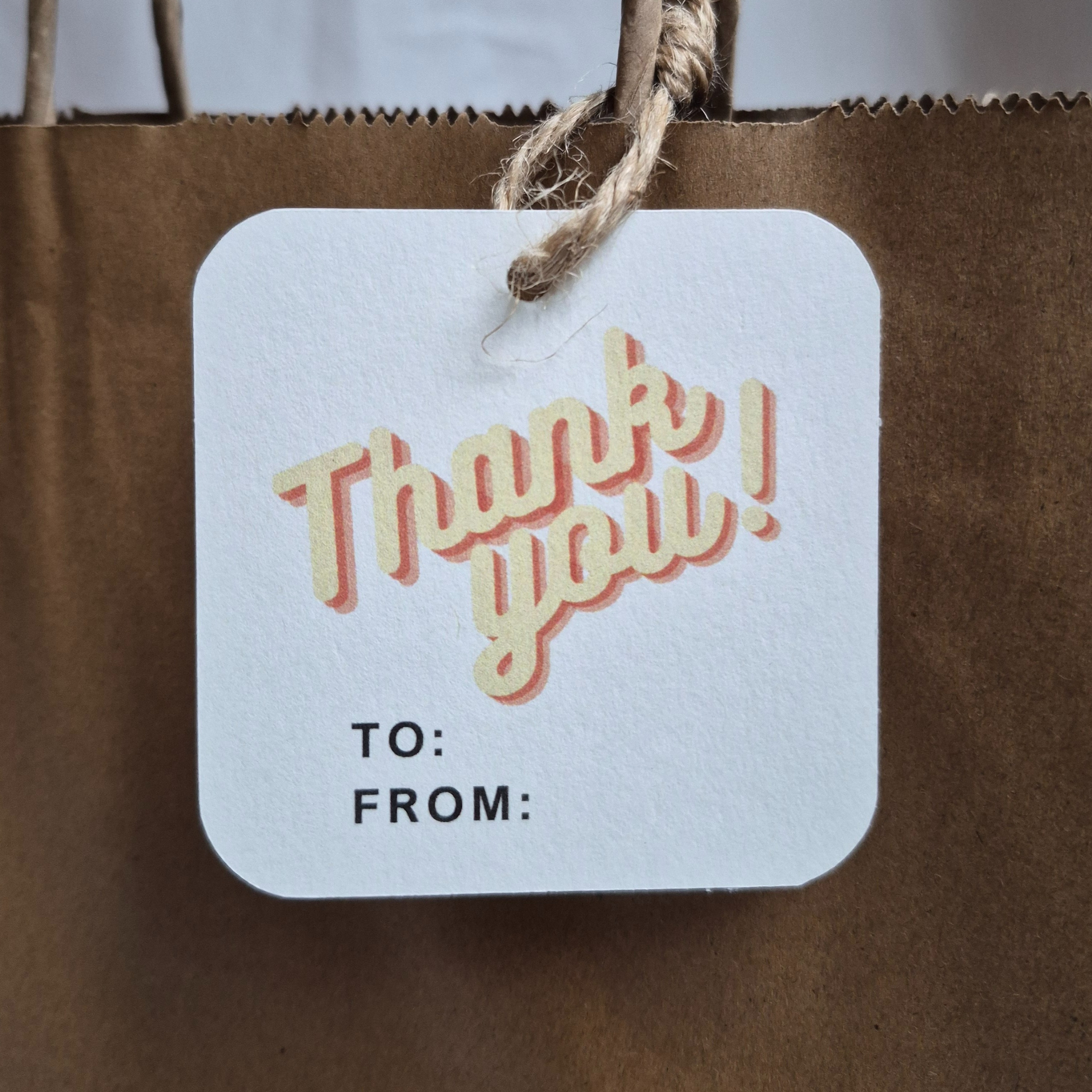 Square recycled paper gift tag with 'Thank you!' text in a retro design